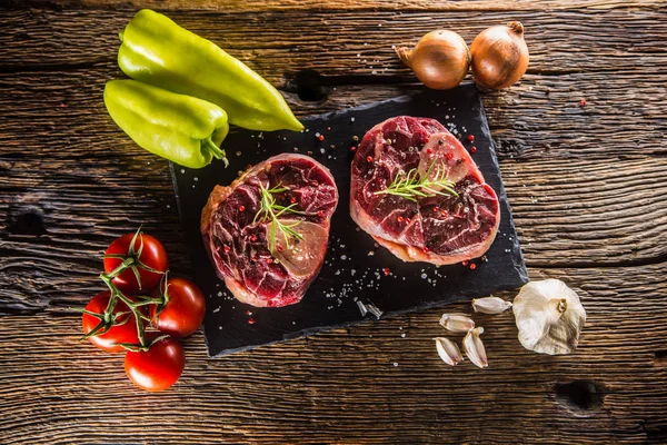 İki adet çiğ dana incik ve temel malzemelerin gulaş - üzerine soğan biber domates tuz baharat ve biberiye sarımsak. 