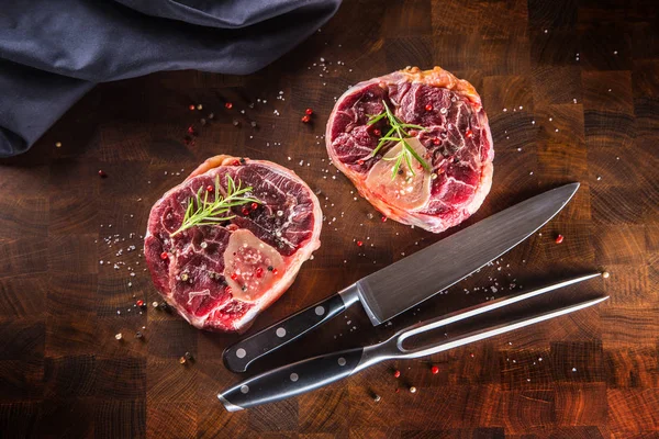 Şaft ahşap kasap gemide iki ham parça çatal ve bıçak ile sığır eti.