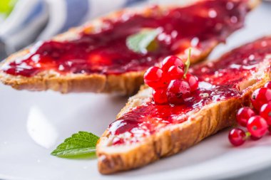 Kırmızı kuş üzümü reçeli kruvasan tereyağı ve nane yaprakları ile lezzetli breakfast.