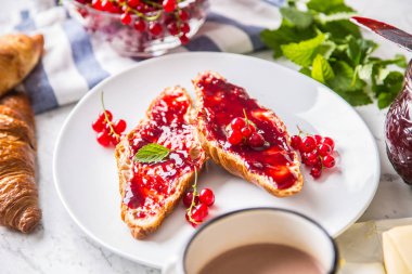 Kırmızı kuş üzümü reçeli kruvasan tereyağı ve nane yaprakları ile lezzetli breakfast.