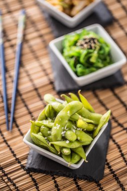 Japanese asian food edamame nibbles, boiled green soy beans with salt. clipart
