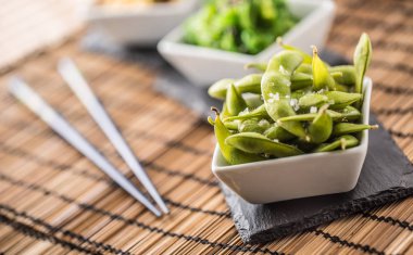 Japanese asian food edamame nibbles, boiled green soy beans with salt. clipart