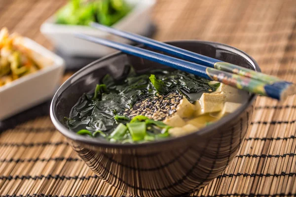 Geleneksel Japon tofu deniz yosunu chopsticks ve Genç soğan ile Miso çorbası.