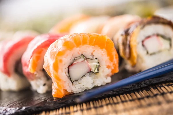 Rulo suşi altın california chopsticks ve soya sosu ile kümesi.