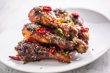 Kavrulmuş ızgara ve Barbekü tavuk budu beyaz plaka üzerinde