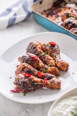 Kavrulmuş ızgara ve Barbekü tavuk budu beyaz plaka üzerinde