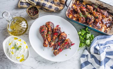 Kavrulmuş ızgara ve Barbekü tavuk budu ot dekorasyonu ile beyaz plaka üzerinde.