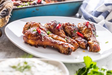 Kavrulmuş ızgara ve Barbekü tavuk budu ot dekorasyonu ile beyaz plaka üzerinde.