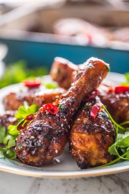 Kavrulmuş ızgara ve Barbekü tavuk budu ot dekorasyonu ile beyaz plaka üzerinde.