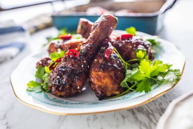 Kavrulmuş ızgara ve Barbekü tavuk budu ot dekorasyonu ile beyaz plaka üzerinde.