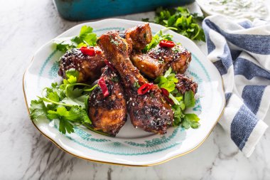 Kavrulmuş ızgara ve Barbekü tavuk budu ot dekorasyonu ile beyaz plaka üzerinde.