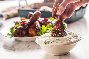 Kavrulmuş tavuk budu kadın el ve tzatziki dip sos veya giyinme.