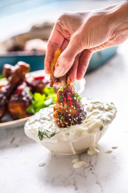 Kavrulmuş tavuk budu kadın el ve tzatziki dip sos veya giyinme.