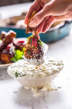 Kavrulmuş tavuk budu kadın el ve tzatziki dip sos veya giyinme.