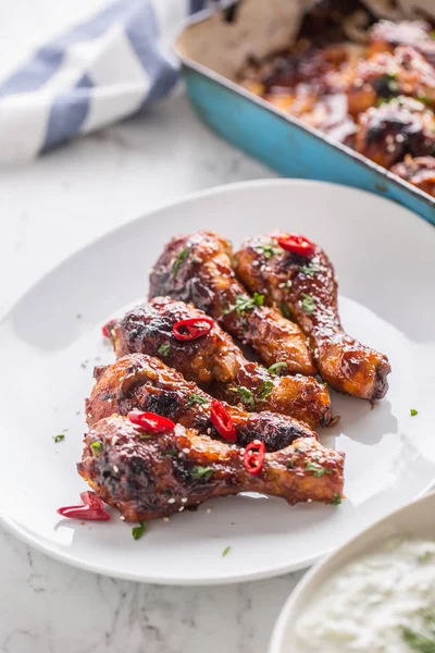 Kavrulmuş ızgara ve Barbekü tavuk budu beyaz plaka üzerinde