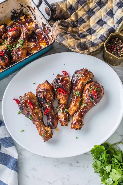 Kavrulmuş ızgara ve Barbekü tavuk budu ot dekorasyonu ile beyaz plaka üzerinde.