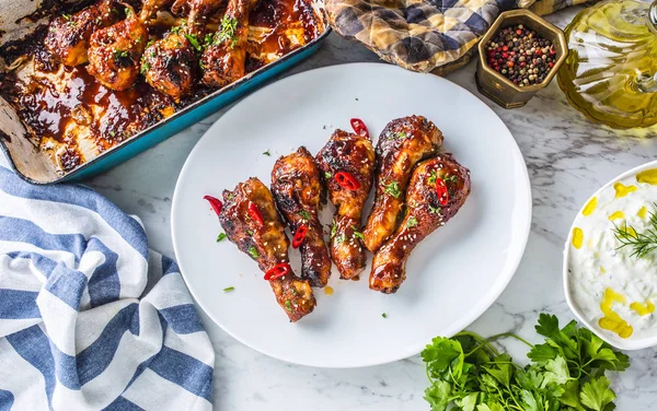 Kavrulmuş ızgara ve Barbekü tavuk budu ot dekorasyonu ile beyaz plaka üzerinde.