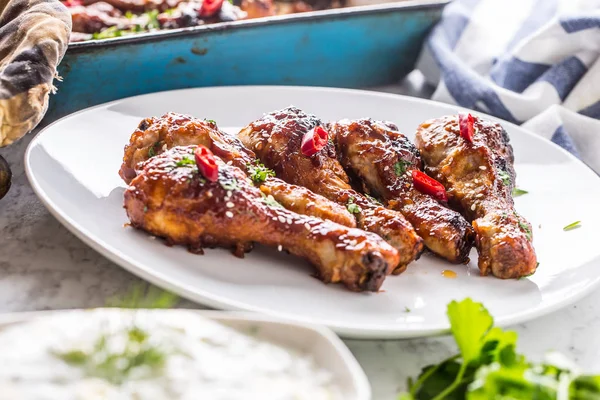 Kavrulmuş ızgara ve Barbekü tavuk budu ot dekorasyonu ile beyaz plaka üzerinde.