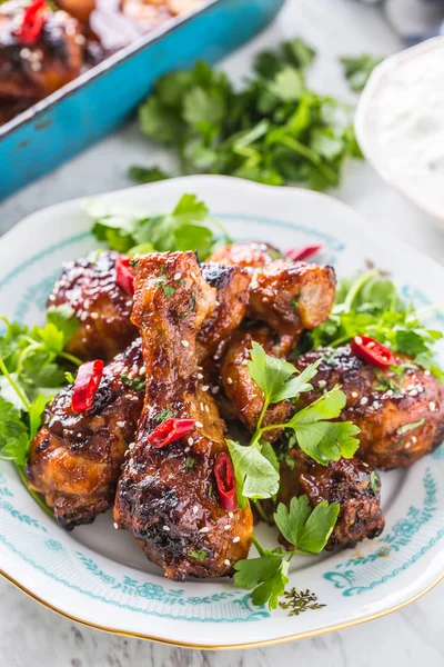 Kavrulmuş ızgara ve Barbekü tavuk budu ot dekorasyonu ile beyaz plaka üzerinde.