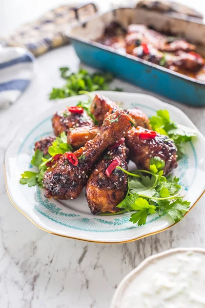 Kavrulmuş ızgara ve Barbekü tavuk budu ot dekorasyonu ile beyaz plaka üzerinde.