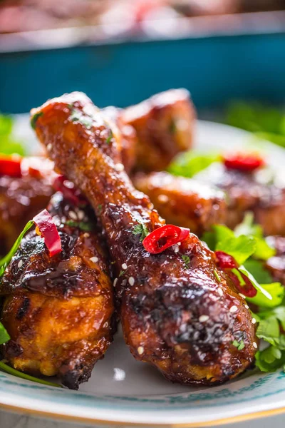 Kavrulmuş ızgara ve Barbekü tavuk budu ot dekorasyonu ile beyaz plaka üzerinde.