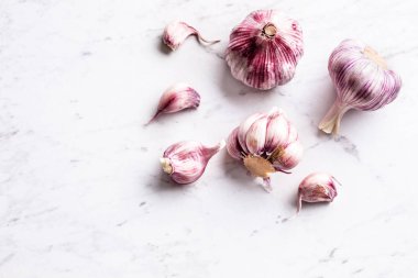 Diş sarımsak ve soğanı beyaz mermer tahta üzerinde.