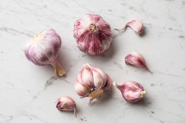 Diş sarımsak ve soğanı beyaz mermer tahta üzerinde.