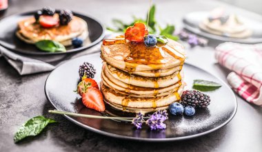 Çilek Böğürtlen yaban mersini lavanta nane yaprakları ve akçaağaç şurubu ile Pancakes.