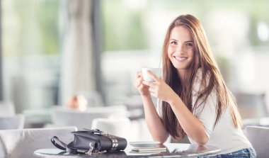 Bir fincan kahve ya da çay kafede olan güzel kadın.