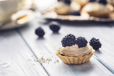 Böğürtlen çırpılmış krema ve kahve ile mini tartlets.