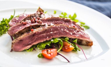 Sulu Külbastı sebze salatası tuz biber ve biberiye beyaz tabakta bölümünü yakın çekim.