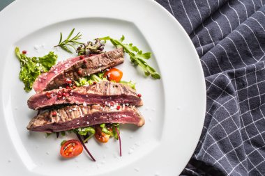 Sulu Külbastı sebze salatası tuz biber ve biberiye beyaz tabakta bölümünü yakın çekim.