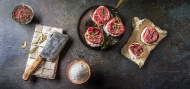 Görünüm bonfile biftek üst pastırma sarılmış. Mutfak gereçler kasap ve pan. Lezzetli sığır eti gıda baharat baharat tuz biber ve biberiye ile.