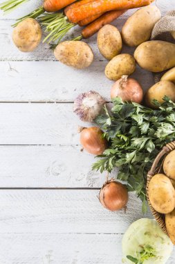 Taze sebze yakın çekim çeşitler. Patates soğan Havuç Kereviz sarımsak ve sarımsak ahşap üzerine.