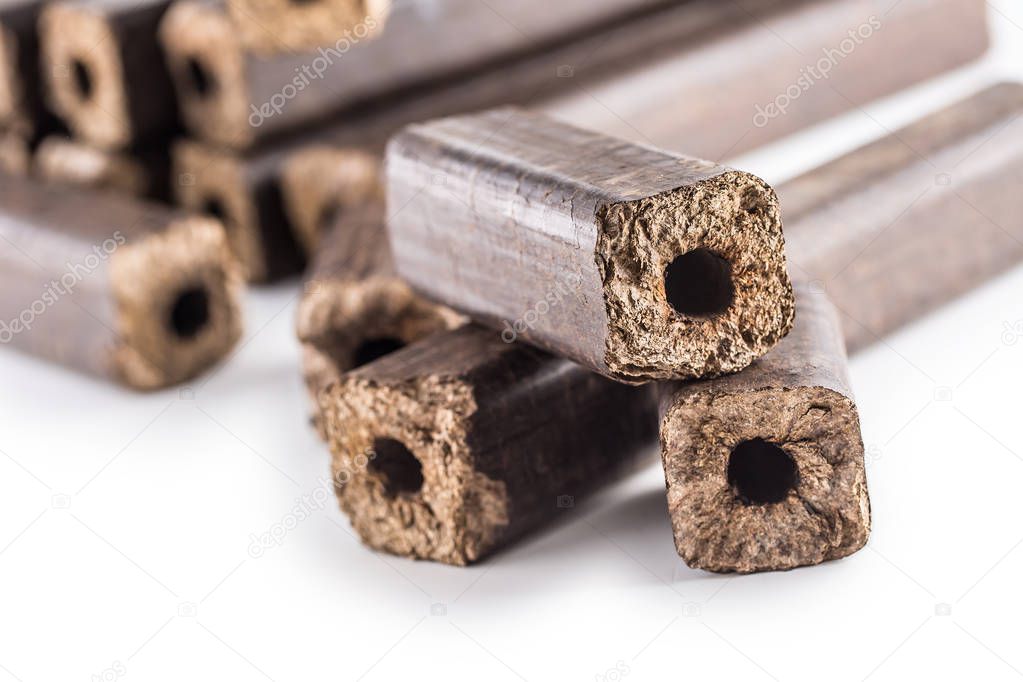Wooden pressed briquettes Pini Kay from biomass on a white isolated background.