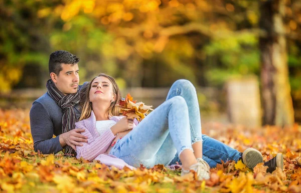 秋天公园里一对相爱的情侣躺在树叶上 — 图库照片