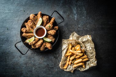 Görünüm kızarmış tavuk kanatları chili sos kireç ve patates kızartması.