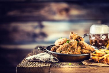 Patates kızartması ve pub ya da restoran tabloda fıçı birayla kızarmış tavuk kanatları.
