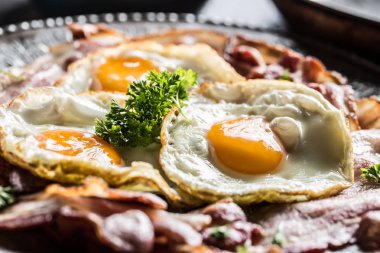 Pastırma ve yumurta plaka üzerinde otlar ile yakın çekim kavrulmuş.