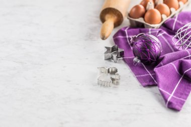 Süslemeler yumurta ve mutfak malzemesi mermer masada Noel pişirme mor hediyeler.