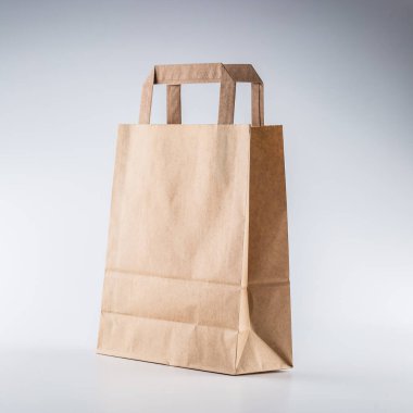 Yakın çekim boş alışveriş el çantası gri arka plan hakkında yeniden işleyip kullanı kağıt.