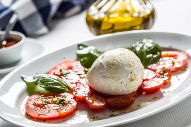 Mozzarella peyniri domates fesleğen zeytinyağı bir baharat üzerinden Caprese salatası.