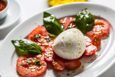 Mozzarella peyniri domates fesleğen zeytinyağı bir baharat üzerinden Caprese salatası.