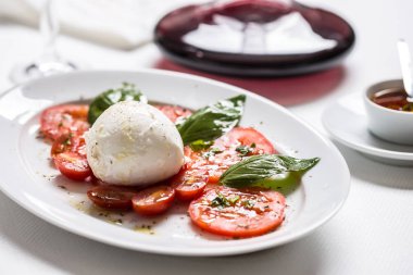 Mozzarella peyniri domates fesleğen zeytinyağı bir baharat üzerinden Caprese salatası.