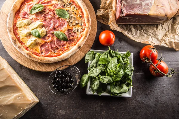 Pizza Quatro Stagioni dört mevsim geleneksel İtalyan yemek enginar mantar domates ham prosciutto parmesan peyniri ve fesleğen - görünümünün üst.