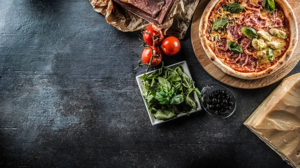 Pizza Quatro Stagioni dört mevsim geleneksel İtalyan yemek enginar mantar domates ham prosciutto parmesan peyniri ve fesleğen - görünümünün üst.