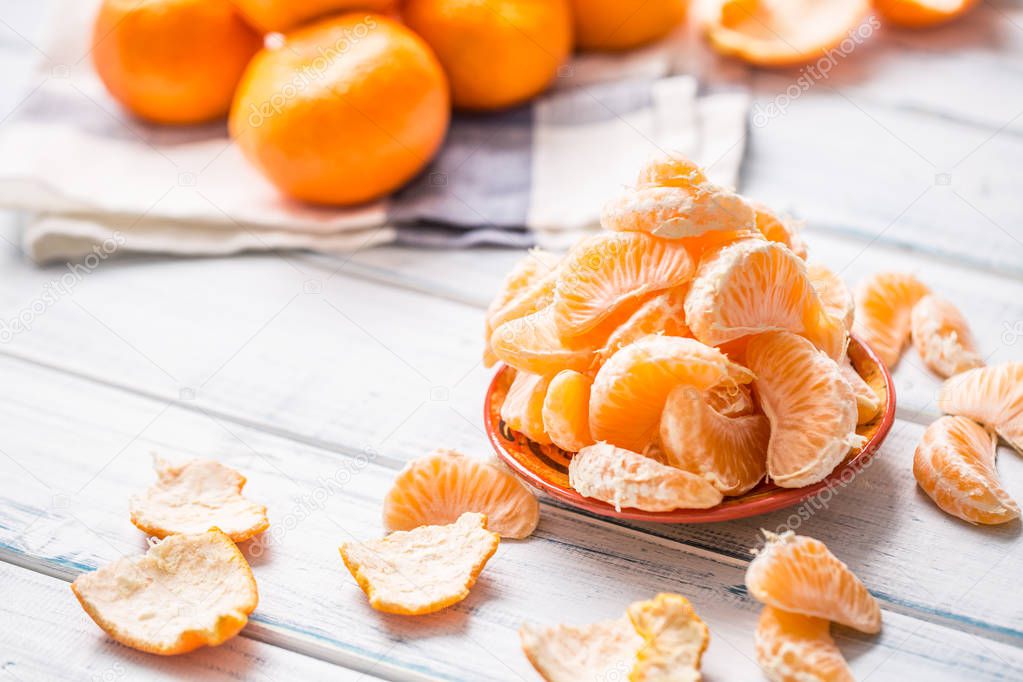 Fresh pieces of tangerines mandarin on the plate or in a bowl.