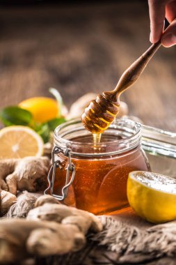 Bal kavanozu kepçe Zencefil limon ve nane otlar ahşap tablo.