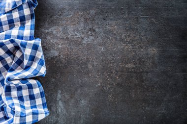 Karanlık beton tablo görünümü mavi kareli masa örtüsü üst.