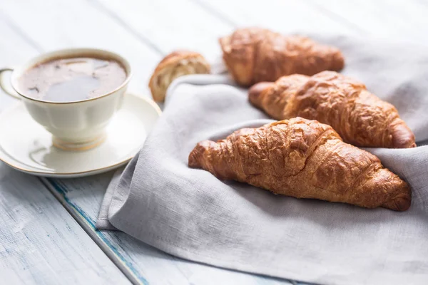 Kahve ile taze tereyağı kruvasan. Tatlı sabah kahvaltı konsepti.